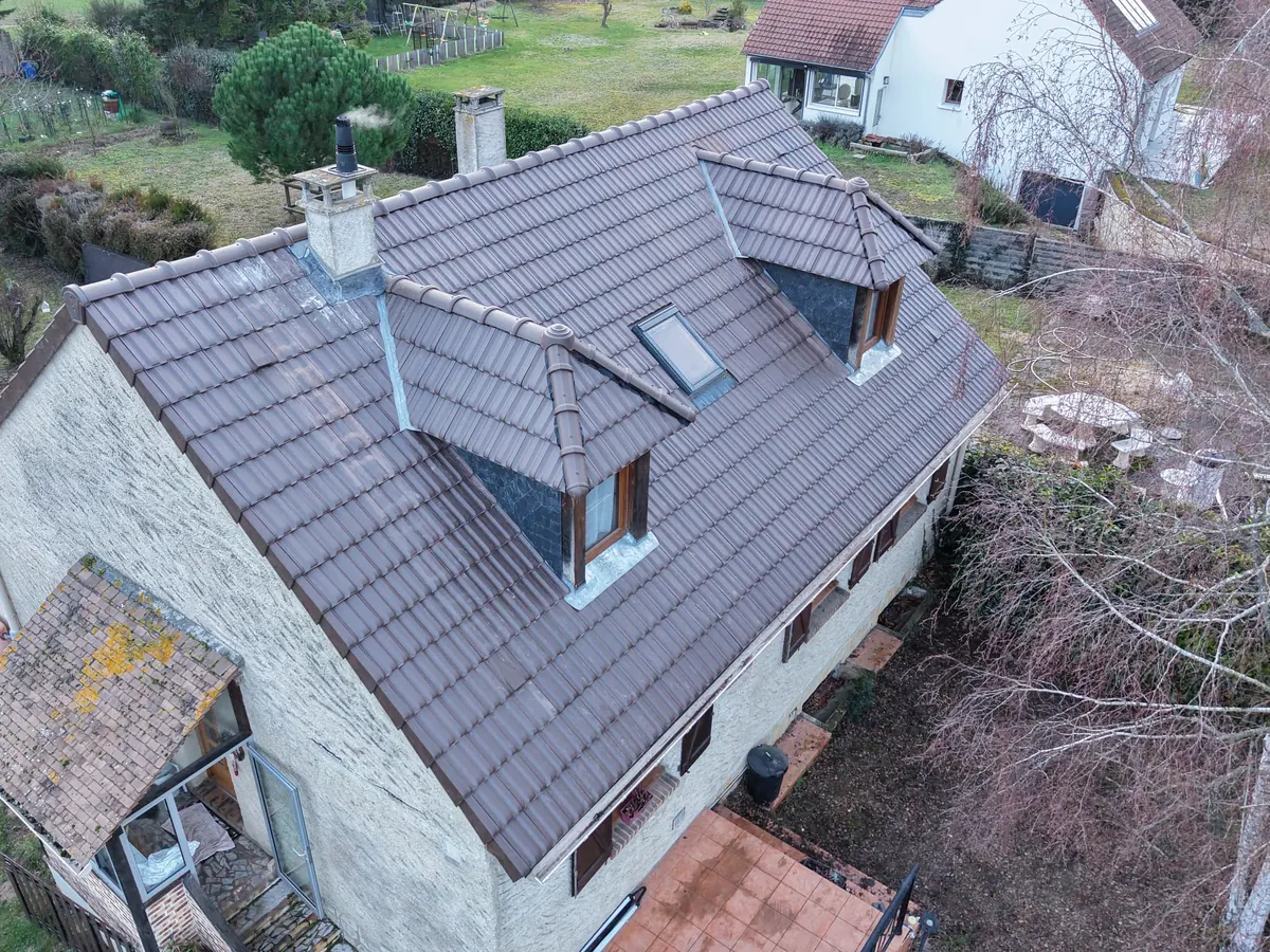 Vue aérienne par drone d'une toiture en tuiles avec ses lucarnes dans l'Essonne