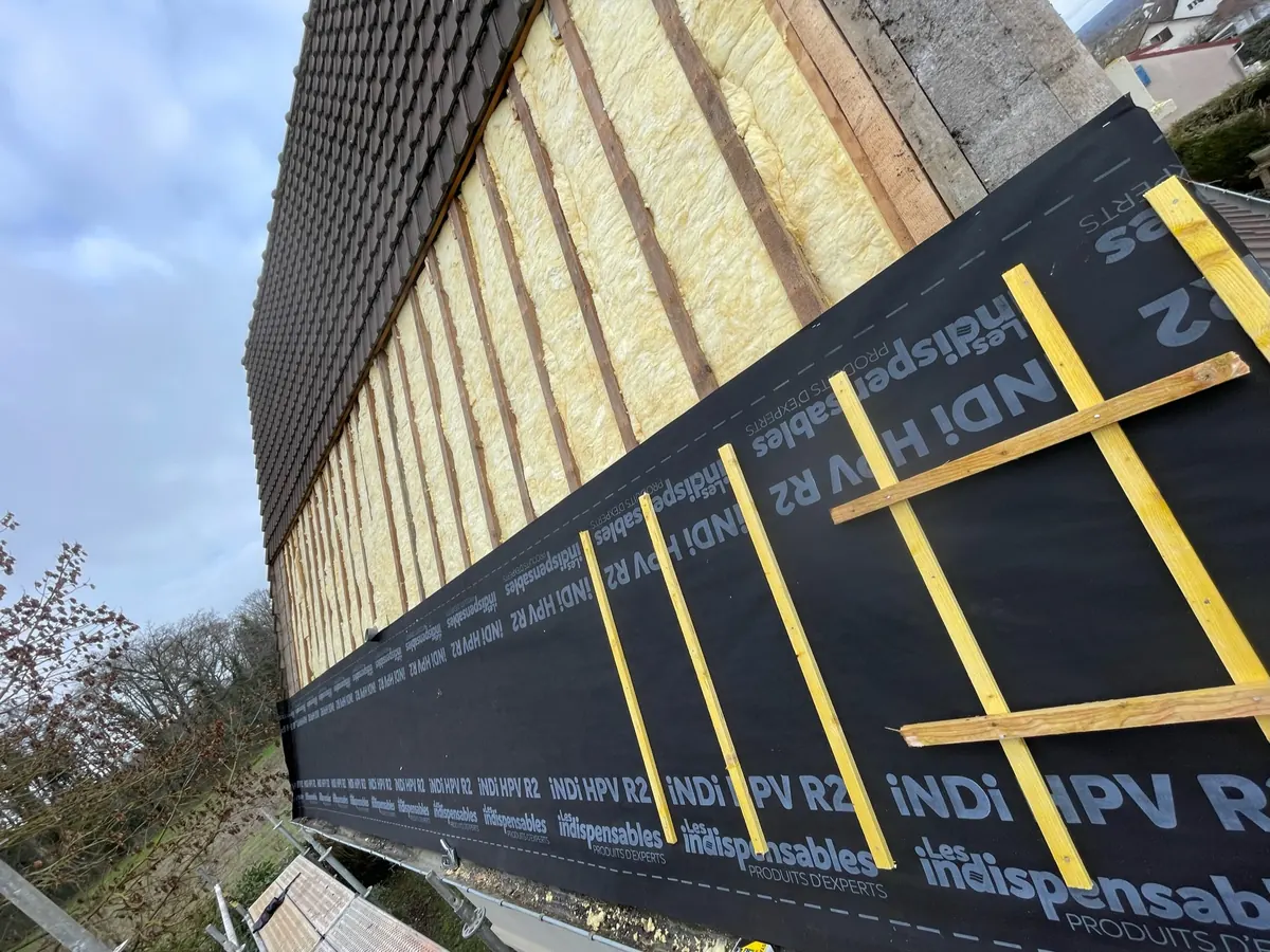 Écran sous-toiture posé sur la charpente avant l'isolation et la couverture dans l'Essonne