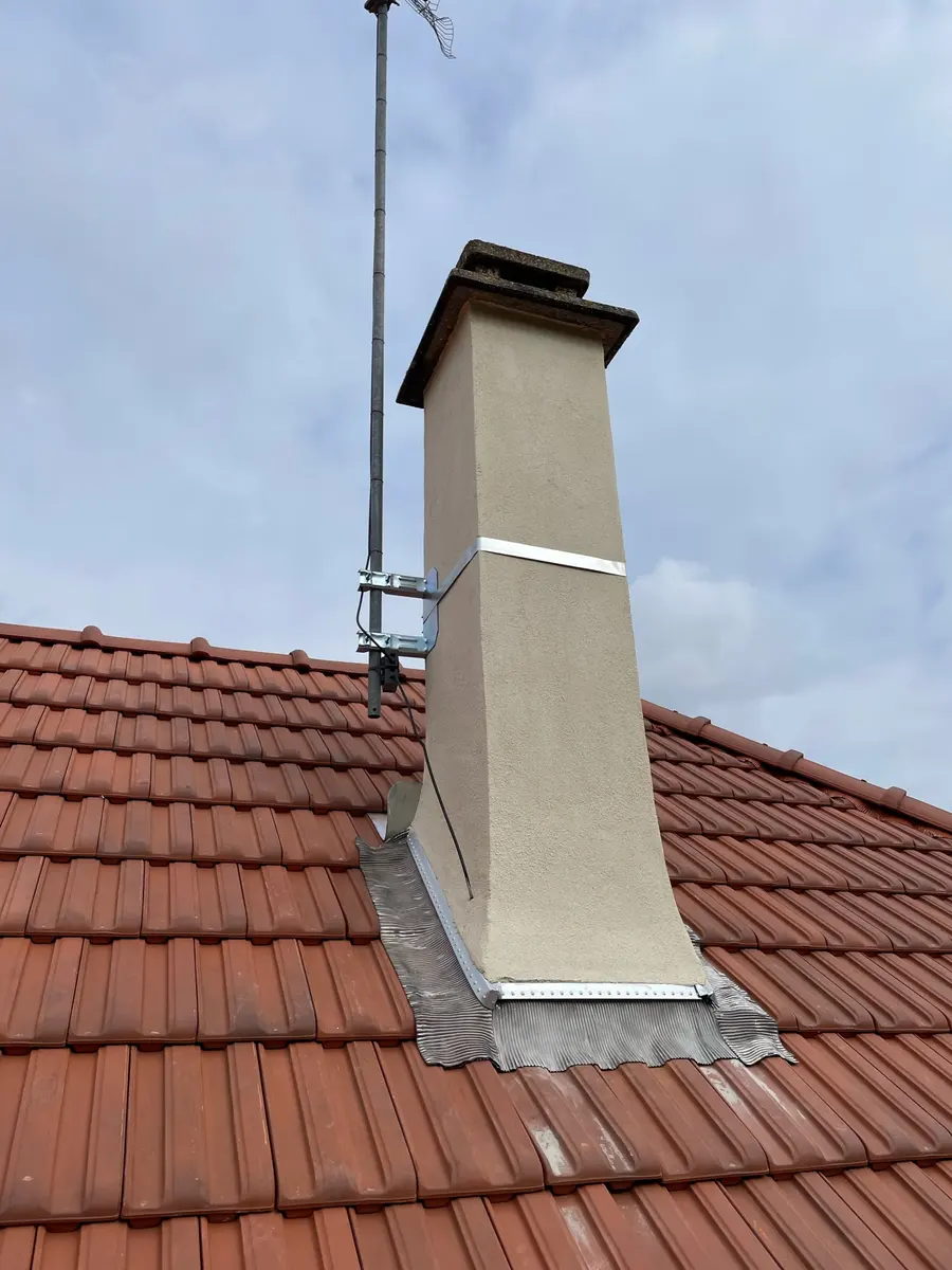 Souche de cheminée et son solin sur une toiture en tuiles