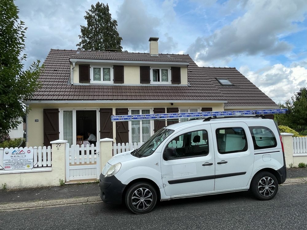 Véhicule de Robert Daniel Couverture devant une maison pour une réparation de toiture dans l'Essonne