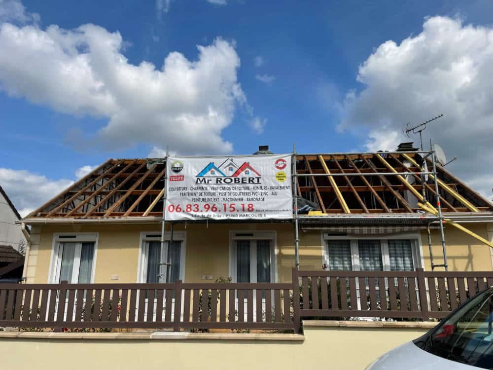 vue sur une toiture en cours de rénovation et vue sur panneau devant toiture